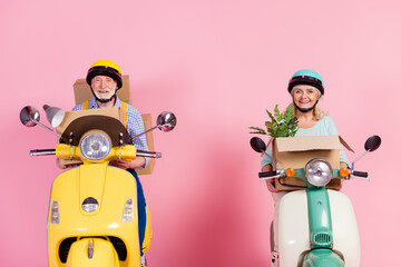 Photo of funky excited senior husband wife driving motorbike dressed helmets carrying staff new home isolated pink color background