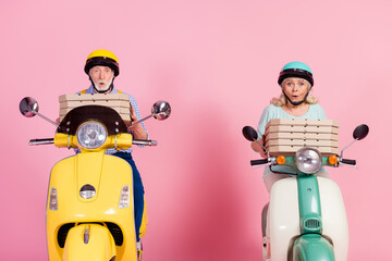 Photo of funny impressed grandmother grandfather riding motorcycle helmets carrying pizza boxes...
