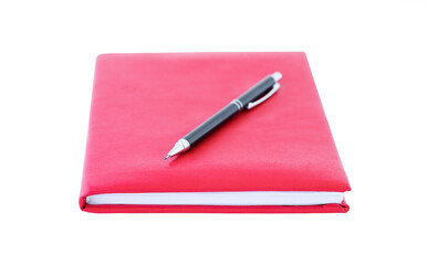 A red notebook and black pen above it isolated on a white background. Education concept, back to school and business concept.
