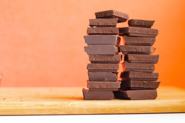 World Chocolate Day pieces of chocolate on an orange background with a copy space