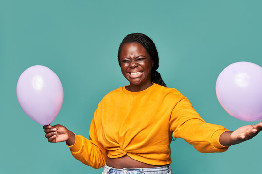 Joyful Black Woman Playing With Balloons In Studio