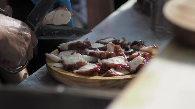 Skillful hands cutting Galician octopus fair style 2