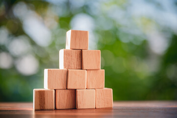 Wood block stacking as step stair to show concepts to strategy business growth to success with natural green background.