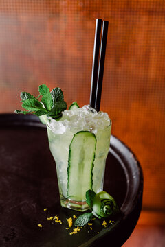 Glass of cold cocktail with mint leaves and cucumber
