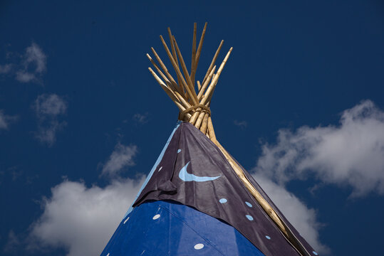 top of a Plains indian teepee showing the support poles and decorative smoke flap.
