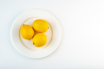 White plate with lemons on white background