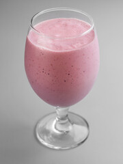 Delicious cold milkshake with raspberries in a glass