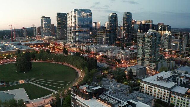 Cinematic 4K drone rise and reveal night footage of the city center of Bellevue, Downtown Park, Bellevue Square, illuminated skyscrapers, office and apartment buildings during blue hour after sunset