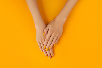Manicured womans with trendy nail design on orange background
