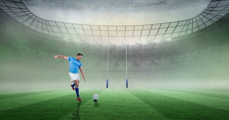 Caucasian male rugby player kicking the rugby ball against stadium in background