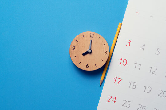 close up of calendar and alaram clock on the blue table background, planning for business meeting or travel planning concept