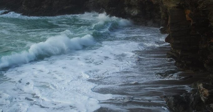 Powerful Foamy Waves Crashing On Coastal Cliffs At Trevellas Cove Near St Agnes, Cornwall, England, UK - aerial static shot