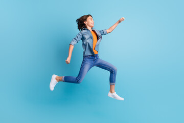 Fototapeta na wymiar Full length profile side photo of young excited boy happy positive smile go run fast hurry jump isolated over blue color background