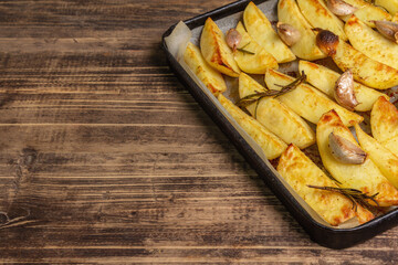 Baked pieces of spiced potato in a baking pan