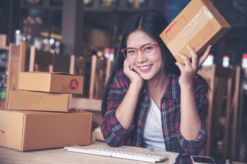 Young entrepreneur, teenager business owner work at home, box for delivery,Beautiful woman holding box post