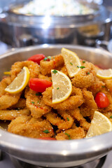 Breaded onion rings with lemon at the buffet