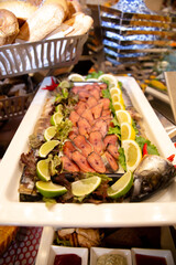 smoked fish sliced with lime slices at the buffet