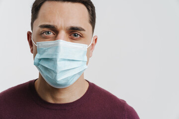 Young brunette man in face mask posing and looking at camera