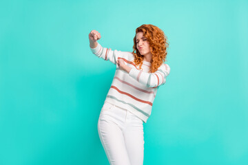 Photo portrait of red haired girl in striped sweater smiling dancing at party isolated vibrant teal color background