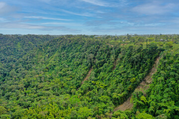 Fototapeta na wymiar Aerial view over a tropical rainforest with large landslide going down a steep cliff