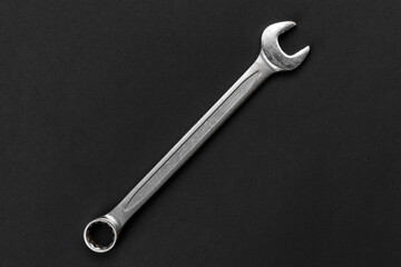 Wrench on black paper background, steel hand work tool