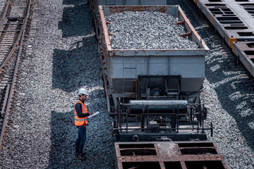 Taken photo from above, railroad engineers inspect railroad tracks and stone-carrying convoys for industrial, he used radio communication and document on hand control work.