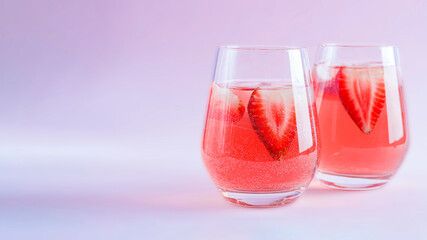 Two glasses of Cooling strawberry Sangria with sparkling wine, strawberry, ice cubes in champagne glass. Refreshing summer alcoholic cocktail drink , lemonade or ice tea. Copy space for text