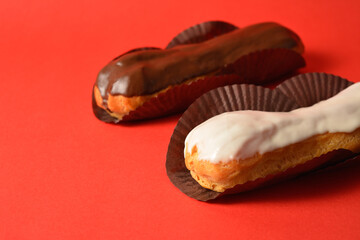 Classic French desserts. One eclair with white chocolate on top and one with dark chocolate, filled...