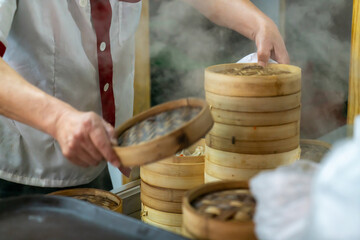 The cook opened the steaming bun in the steamer