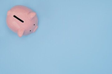 Top view of pink piggy bank for money saving isolated on light blue background with clipping path.