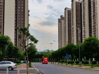 Naklejka premium A road in an area with tall residential buildings. Cars and Trees. Guangzhou. Guangdong. China. Asia. 