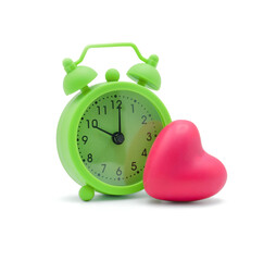Green alarm clock with pink heart isolated on white background with copy space. Time for love and healthy concept.