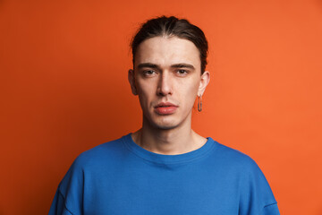 Young white man with earring posing and looking at camera