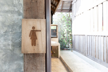 restroom. old wood toilet sign with soft-focus and over light in the background