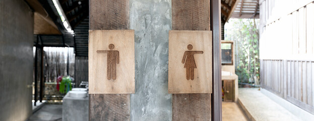 restroom. old wood toilet sign with soft-focus and over light in the background