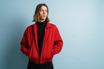 Young white man wearing red jacket posing and looking aside