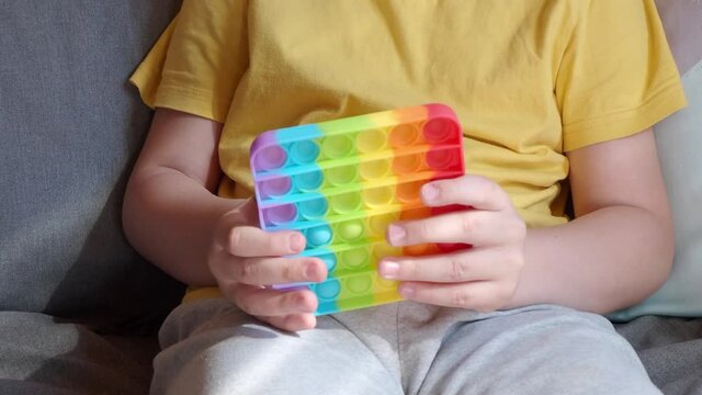 colorful anti-stress sensory fidget push pop it toy in children's hands