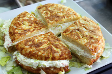 tortilla española de patatas, rellena de ensaladilla rusa