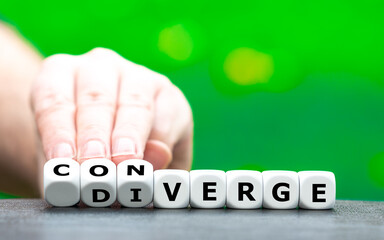 Hand turns dice and changes the word "diverge" to "converge".
