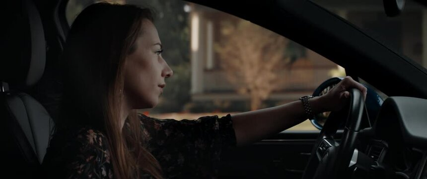CU Portrait of attractive Caucasian female texting while driving her car through neighborhood. Shot with 2x anamorphic lens