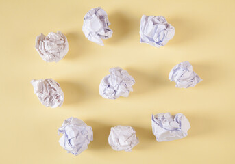Set of crumpled paper balls, on an isolated yellow background.