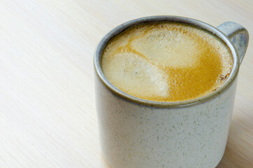 Mug with black coffee and froth. A fragrant strong invigorating drink for breakfast. Time to drink coffee