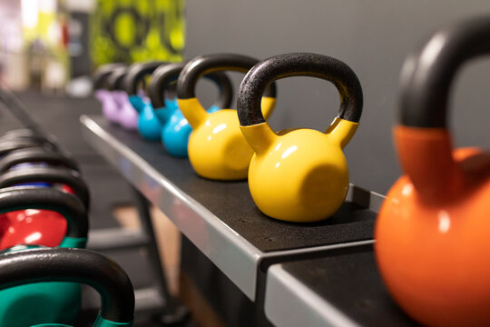 Colorful kettlebells placed on shelf in gym