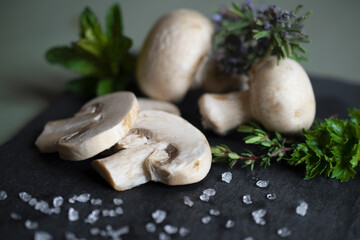 Composizione di funghi freschi ed erbe aromatiche su di un piatto di ardesia.