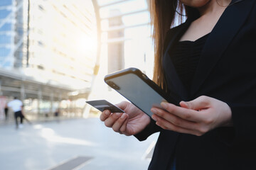 Online payment,Woman's hands holding a credit card and using smart phone for online shopping.