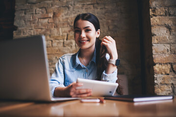 Positive woman using tablet at work