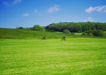 two people on a meadow biking on a sunny summers day © T