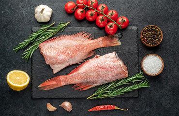 Raw red sea bass fish on stone background