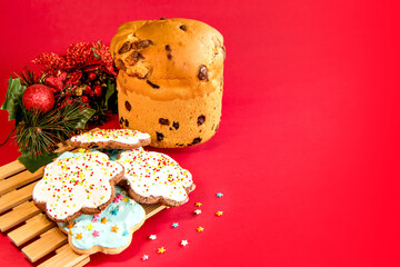 Panettone and Christmas cookies on red background. Christmas dessert.