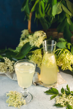 Soft drink with ice cubes from elderflower syrup, juice or champagne in a glass